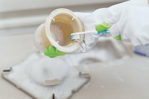 排水溝歯ブラシで洗う