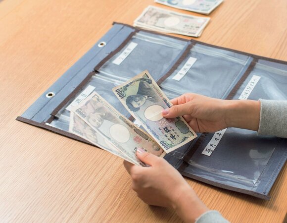 予算を銀行で下ろしてポケットに入れる