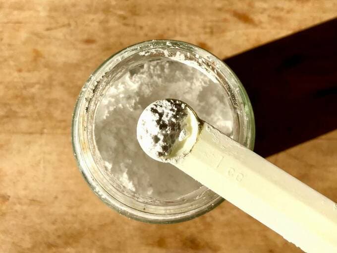 ビンからスプーンですくったパウダー