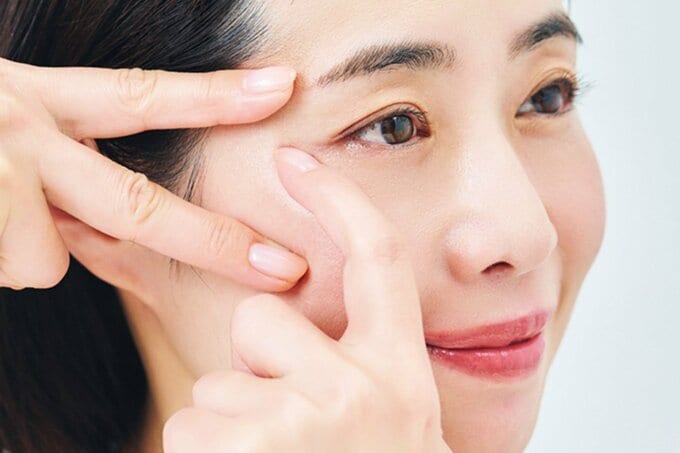 目尻にアイクリームを塗る様子