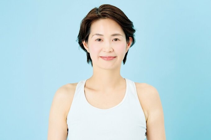 口を閉じているタンクトップ姿の女性