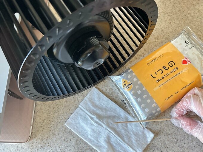 写真：串とクリーナーで換気扇を掃除