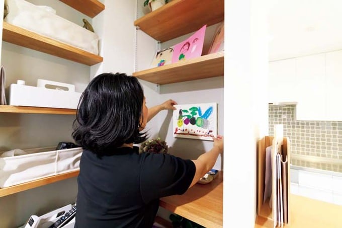 ニッチに子どもが学校でつくってきた作品を飾る妻