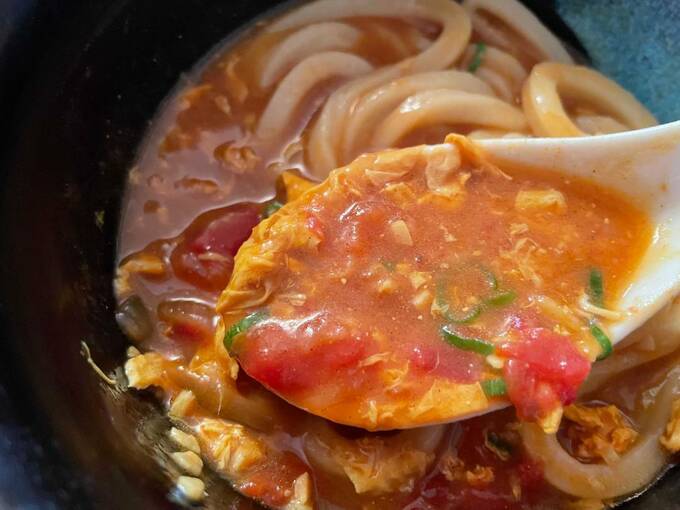 トマたまカレーうどんをすくう様子