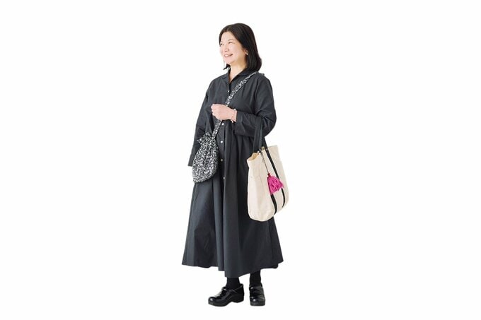 斜めがけバッグとトートバッグを持って立つ女性