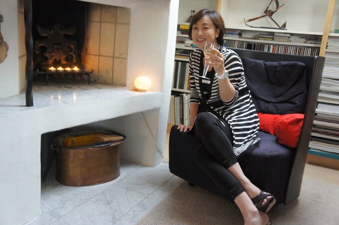 暖炉の前にいる川上麻衣子さん