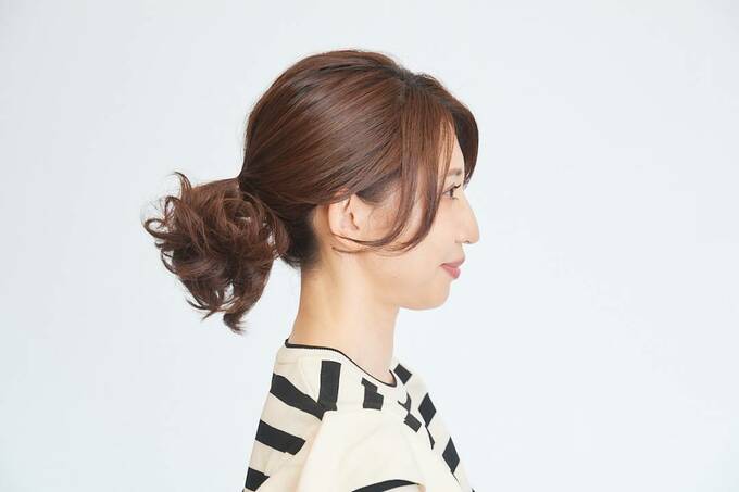 耳の上あたりで髪の毛を結んでいる女性