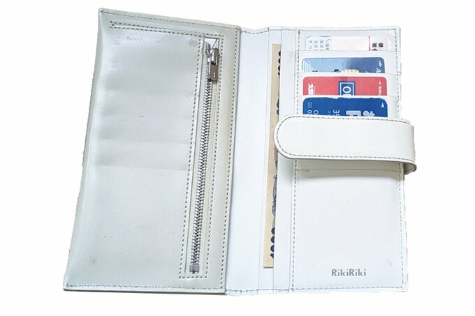 お金やカード類が入った白い長財布