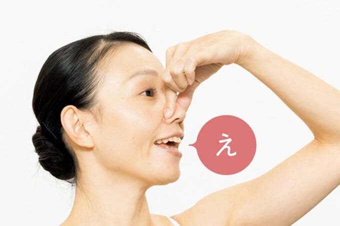 鼻をつまんで「え」の口の動きをする女性