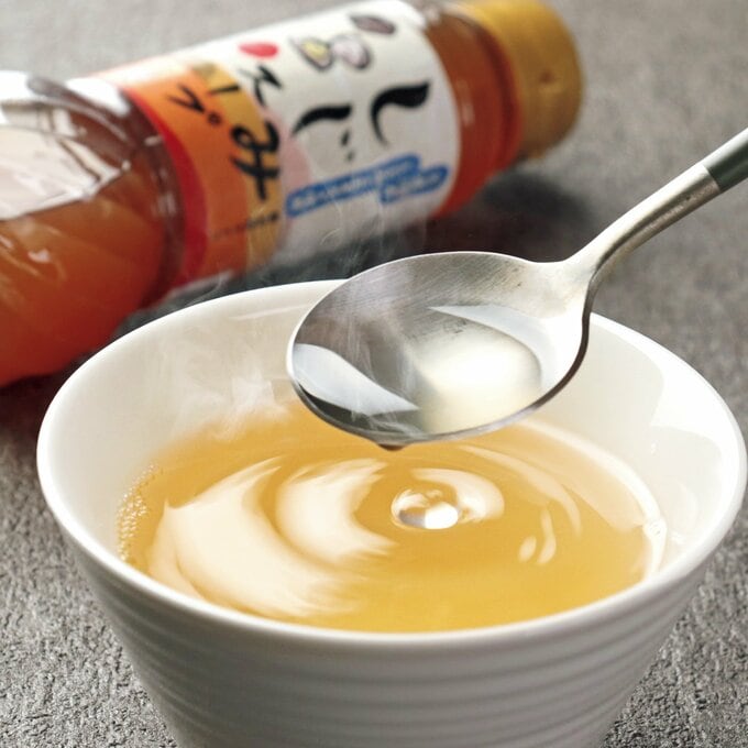 黄金色のスープをスプーンですくう様子
