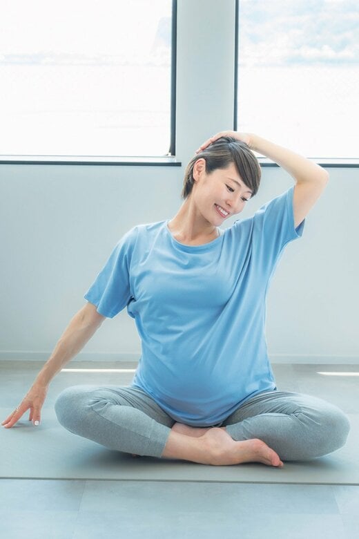 頭に手を当て首を伸ばすヨガのポーズ