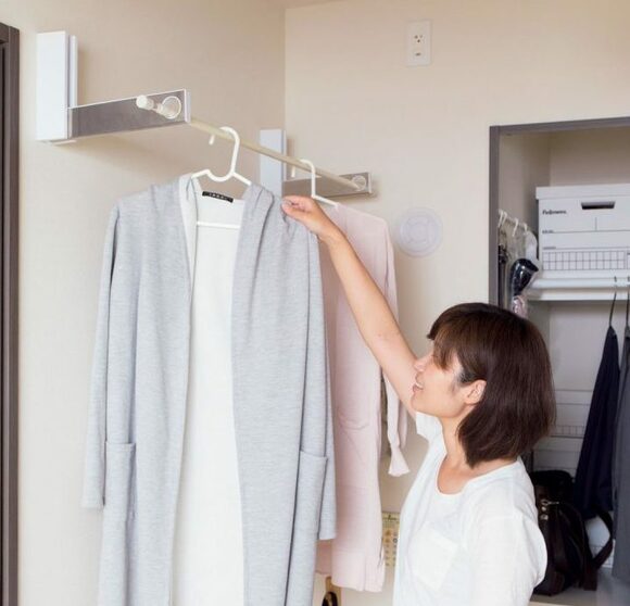 たためるコート掛けと女性