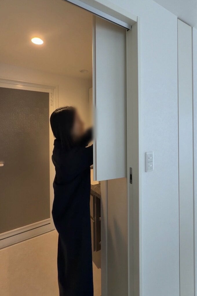 棚に手を伸ばす女性