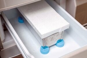 冷凍室では冷気が循環するようペットボトルのフタでかさ上げ