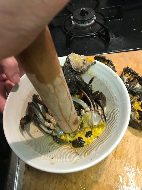 すり鉢でカニを潰す