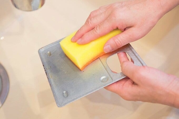 トレーの汚れを流水で洗い流す