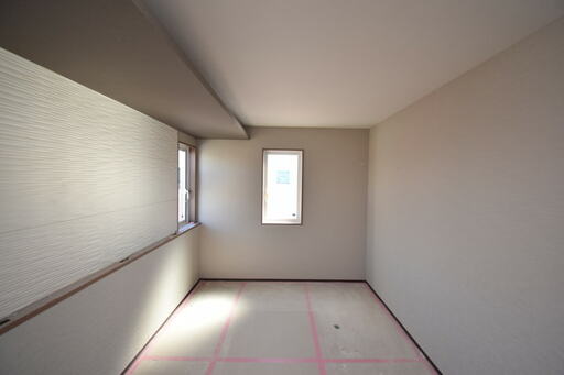 ベージュ×ブラウン2色のクロスが貼られた主寝室