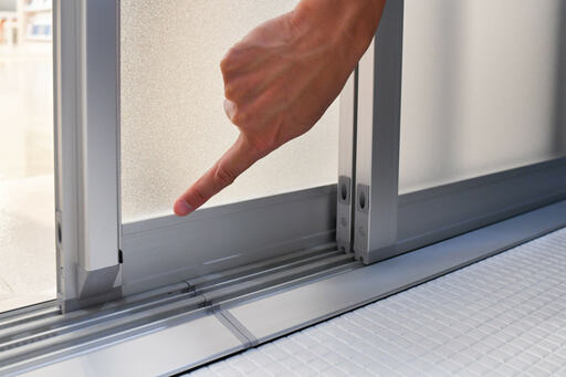 ドアの下枠を指でなぞる様子