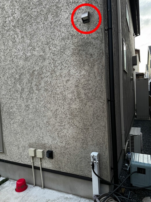 家の東側の外壁。上の高い位置にコンセントがある。下に屋外水栓がある。