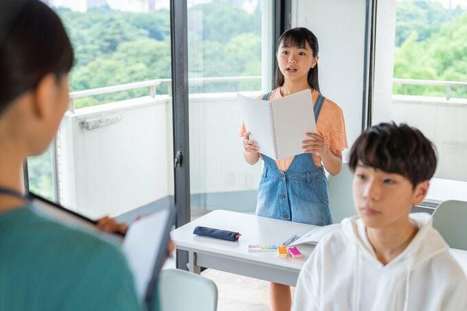 クラスで発表する女子小学生