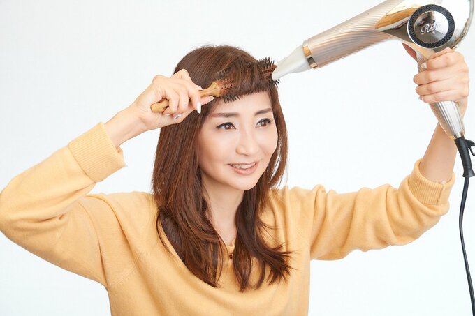 前髪をスタイリングする女性