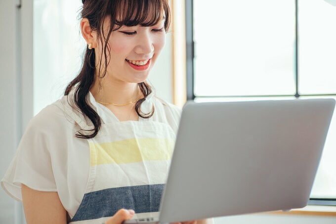 PCを見てほほ笑む女性