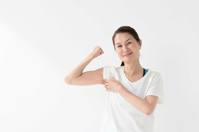 力こぶに力をいれる女性