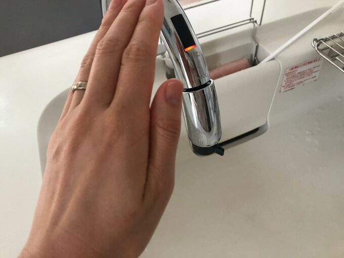 タッチレス水栓に手をかざす様子