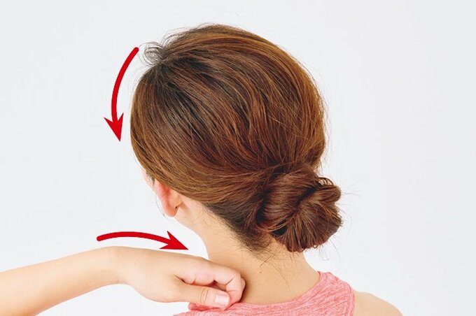 こぶしを首に当て、頭を斜め後ろに傾ける