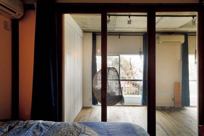 ガラスの間仕切り戸越しに屋外の景色がのぞめる寝室