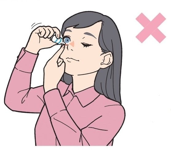 目薬を角膜に当てている女性