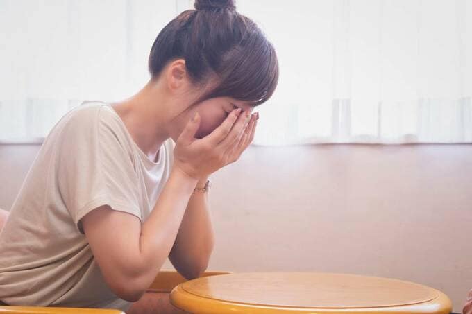 顔をおさえる女性
