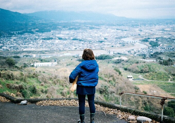 街並みを見渡す女性と犬