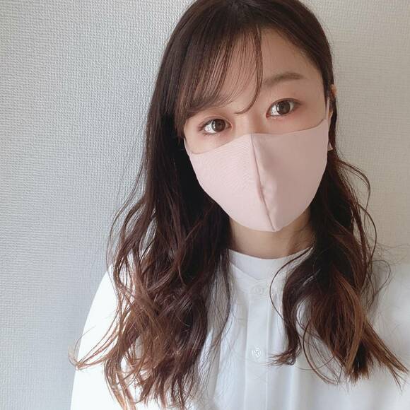 パステルピンクのマスクをつけた女性