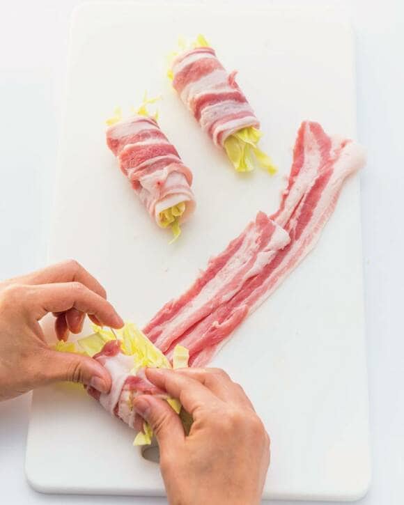豚肉にキャベツをのせて巻く様子