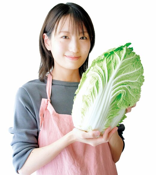 大きい白菜を持ってほほ笑む長谷川さん