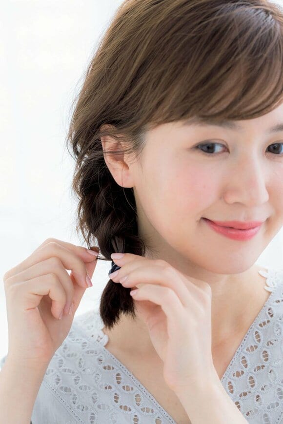 ゴムの結び目を押さえながら、ゆるふわ感を出す様子