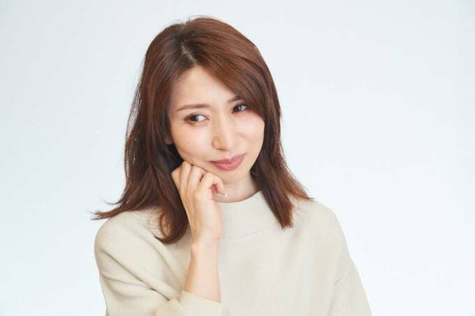 頬に手をおいて悩んでる女性