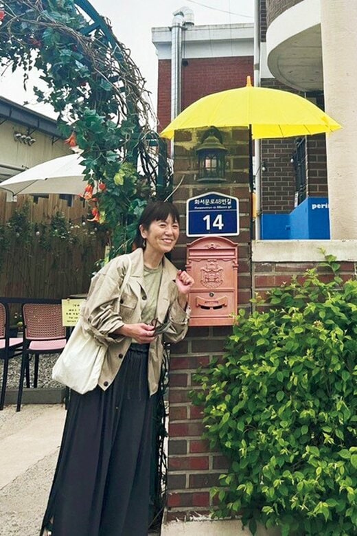 ポストの横に立つワタナベマキさん