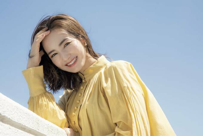 頭を抱える黄色い服を着た女性