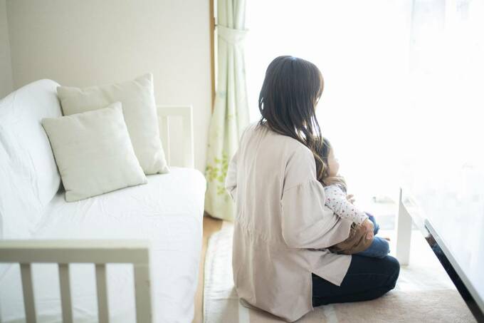 子どもを抱っこして座る女性