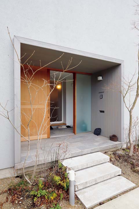 半透明のガラスと木製引き戸で開放感を感じさせる玄関