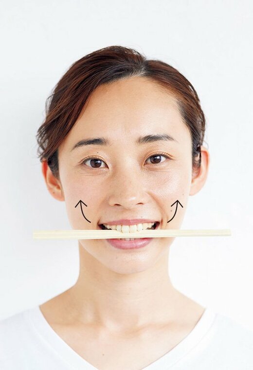割り箸を口にはさむ女性