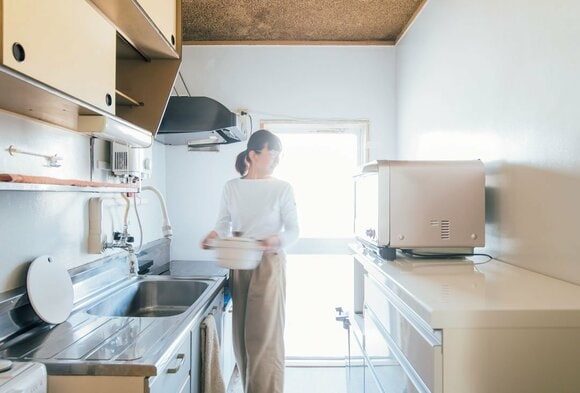 女性キッチンでお鍋を持つ