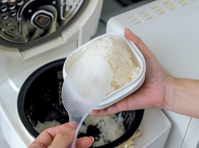 炊飯器のごはんを容器に移している様子