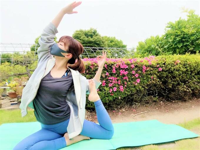 ヨガをするスポーツマスクをつけた女性