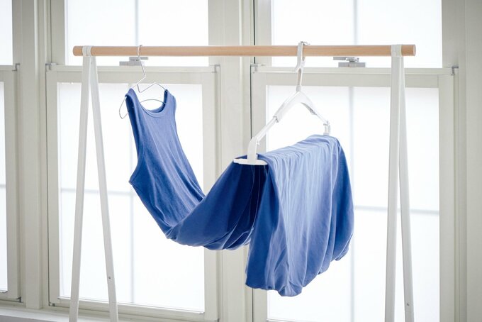 ブルーのワンピースが2本のハンガーを使って干されている様子