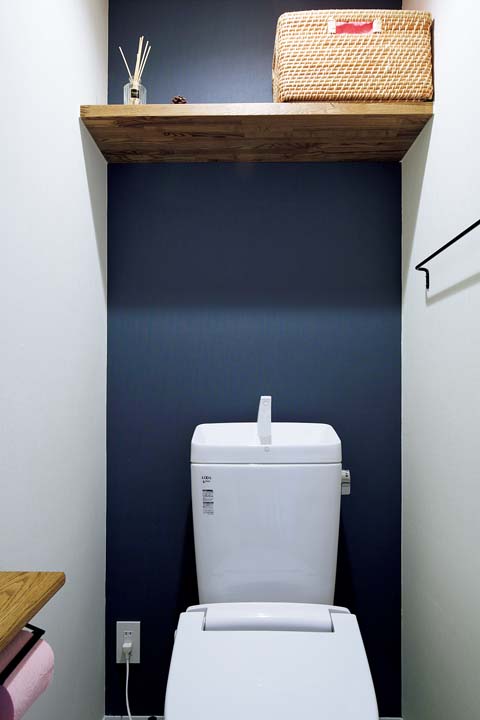 壁の1面にネイビーのクロスを使ったトイレ