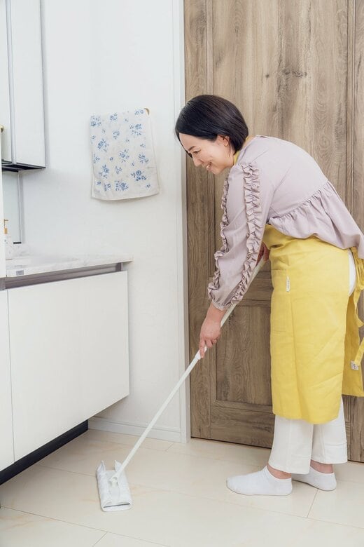 洗面所をフロアワイパーでふく女性