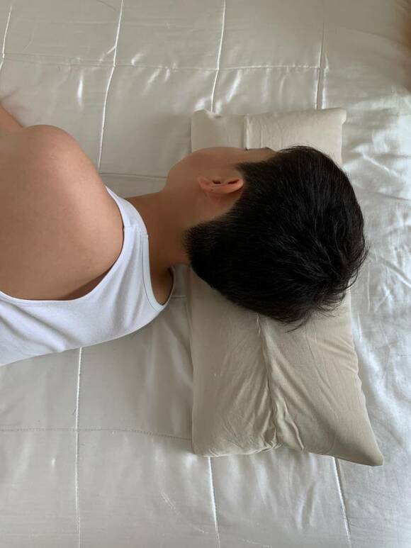 男性が枕を使って横になっている様子